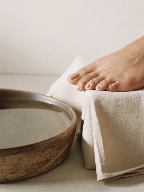 A pedicure detail beside a stoneware basin